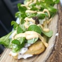 Foto de Tosta de focaccia con carrillada ibérica, cebolla caramelizada, queso fundido, rúcula y emulsión de chile torrado